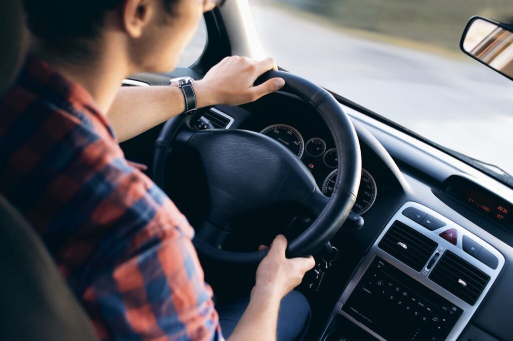 Crafting Captivating Headlines: Your awesome post title goes here Close-up view of a man driving a modern car, showing dashboard and steering details.
