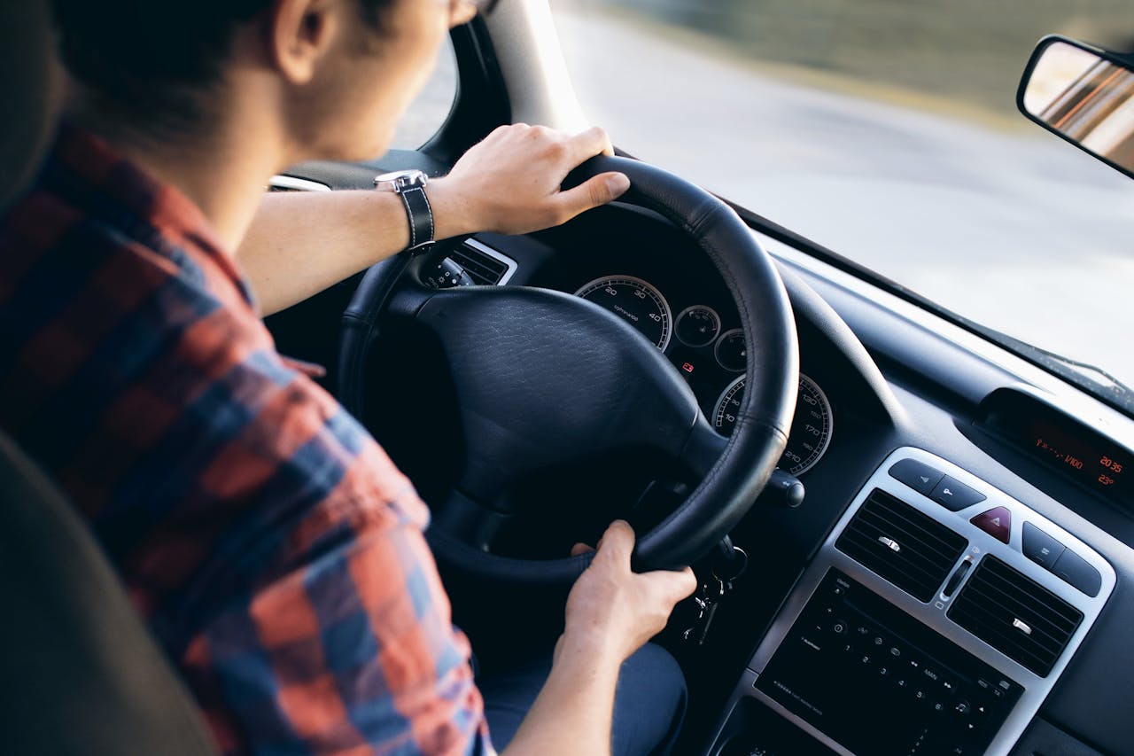 Crafting Captivating Headlines: Your awesome post title goes here Close-up view of a man driving a modern car, showing dashboard and steering details.